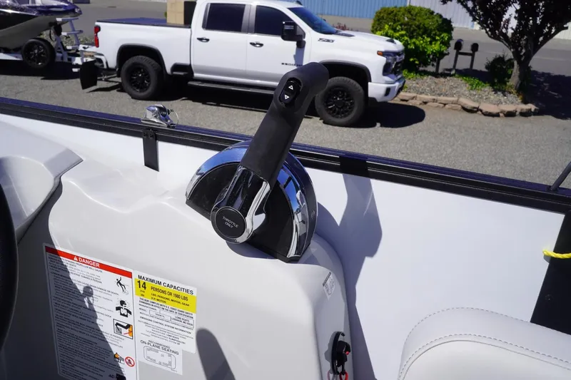 Slide: The Image of Boat throttle control on a 2025 Lowe SS 230, with a truck in the background. - 21