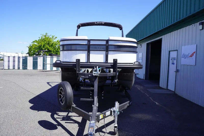 Slide: The Image of 2025 Lowe SS 230 boat on trailer outside a warehouse. - 4