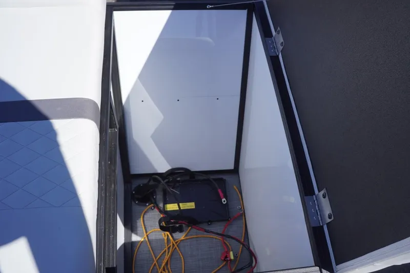 Slide: The Image of Storage compartment in a 2025 Lowe SS 230 boat with battery and cables. - 41