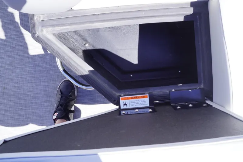 Slide: The Image of 2025 Lowe SS 230 boat interior with storage compartment and warning label. - 42