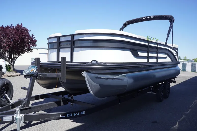 Slide: The Image of 2025 Lowe SS 230 pontoon boat on trailer, parked outdoors. - 5