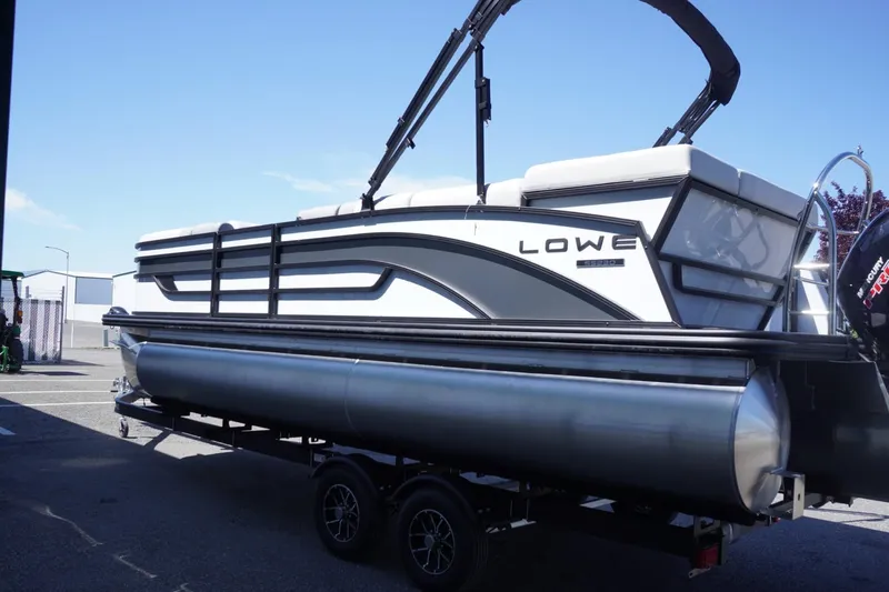 Slide: The Image of 2025 Lowe SS 230 pontoon boat on trailer, side view, outdoors. - 7