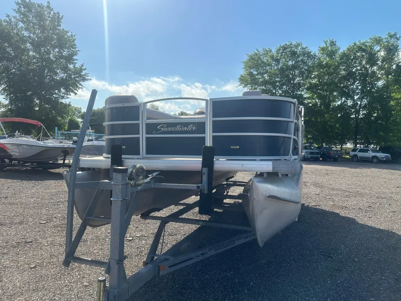 Slide: The Image of 2015 Godfrey Sweetwater 220 Premium Edition pontoon boat on a trailer in a sunny outdoor setting. - 10
