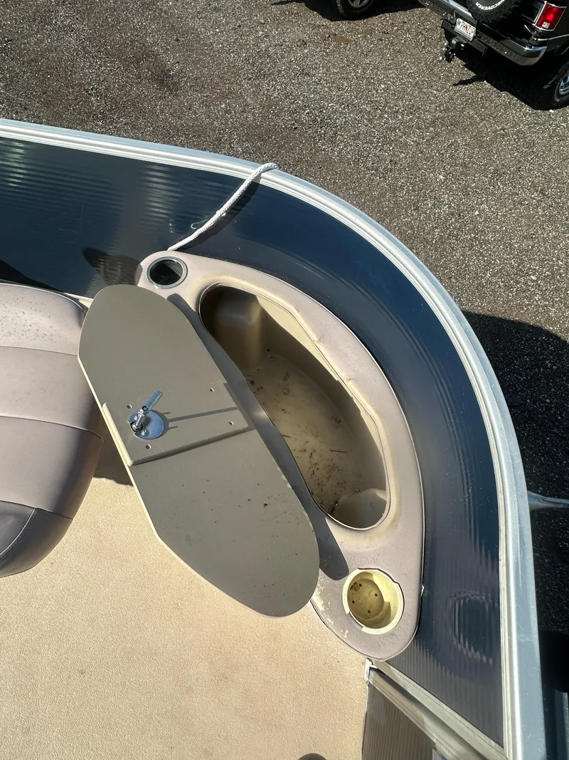 Slide: The Image of 2015 Godfrey Sweetwater 220 Premium Edition boat interior with storage compartment and cup holder. - 13
