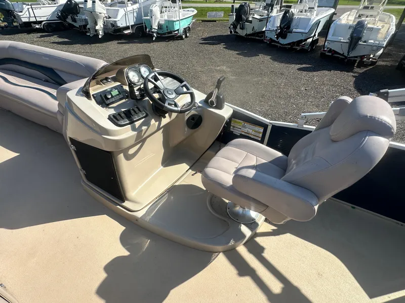 Slide: The Image of 2015 Godfrey Sweetwater 220 Premium Edition boat interior with captain's chair and control panel. - 16