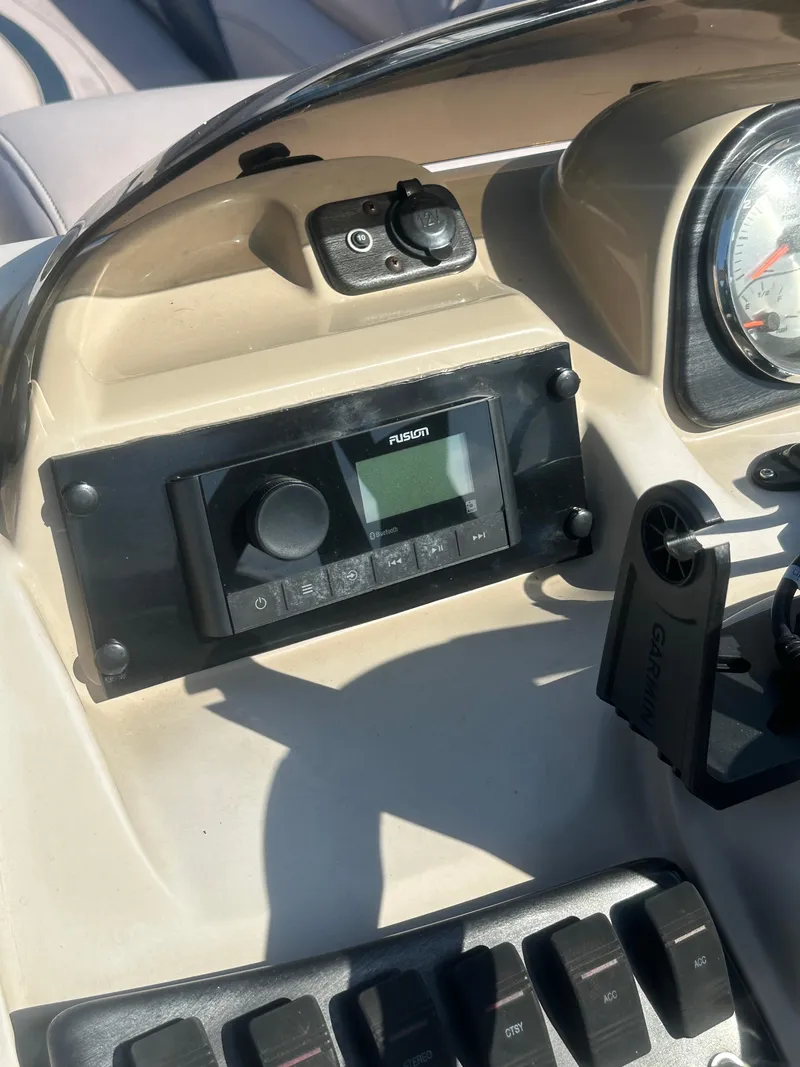 Slide: The Image of Control panel of 2015 Godfrey Sweetwater 220 Premium Edition boat, featuring a radio and gauges. - 17