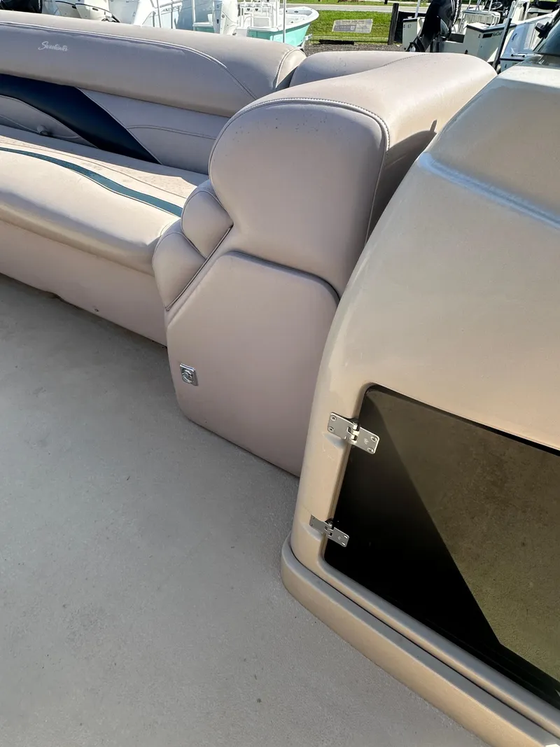 Slide: The Image of 2015 Godfrey Sweetwater 220 Premium Edition boat interior with beige seating and storage compartment. - 20