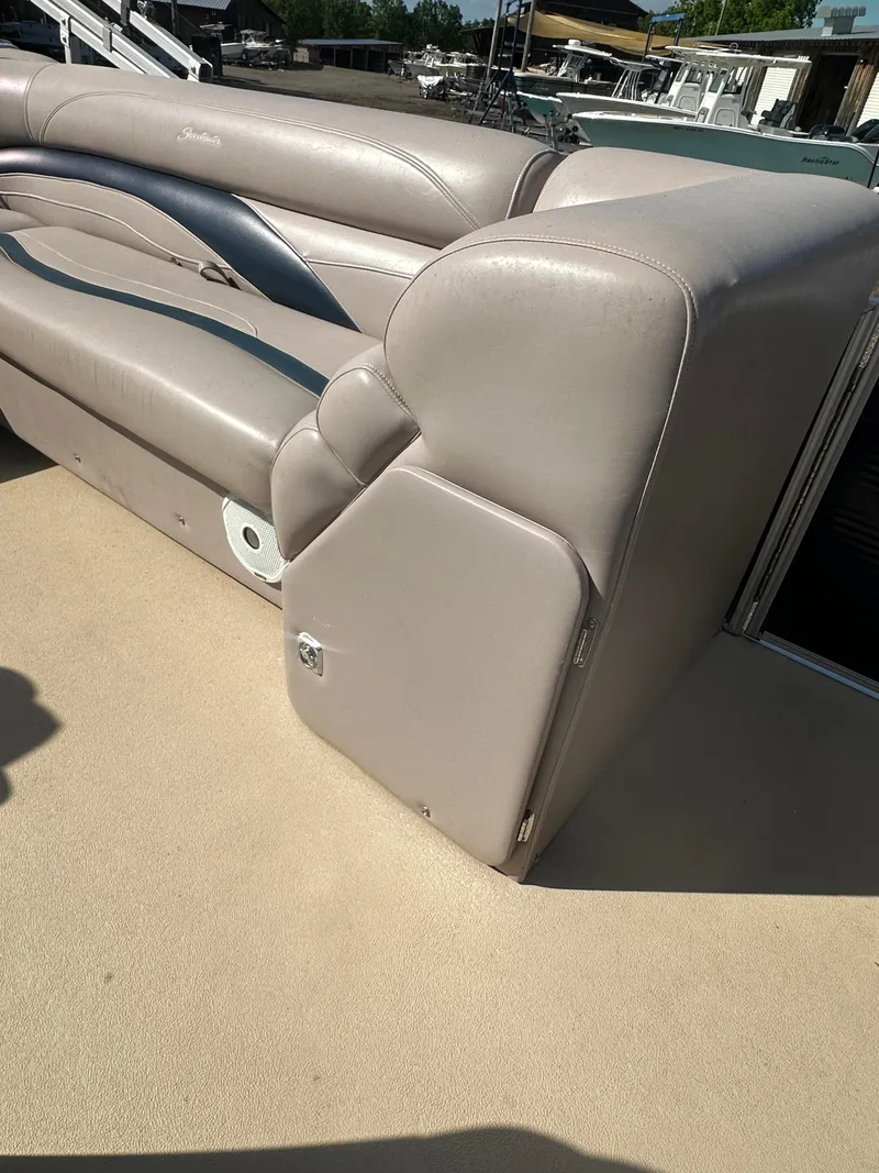 Slide: The Image of 2015 Godfrey Sweetwater 220 Premium Edition boat seating, beige upholstery, sunny day. - 21