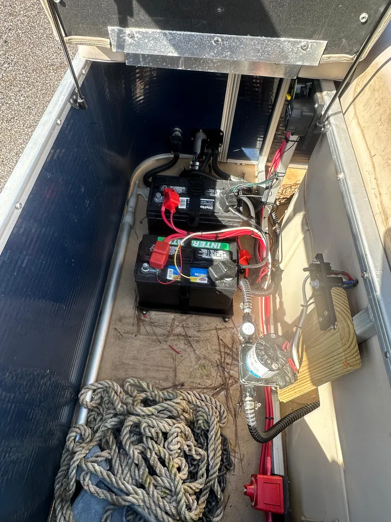 Slide: The Image of 2015 Godfrey Sweetwater 220 Premium Edition boat storage compartment with battery and rope. - 22