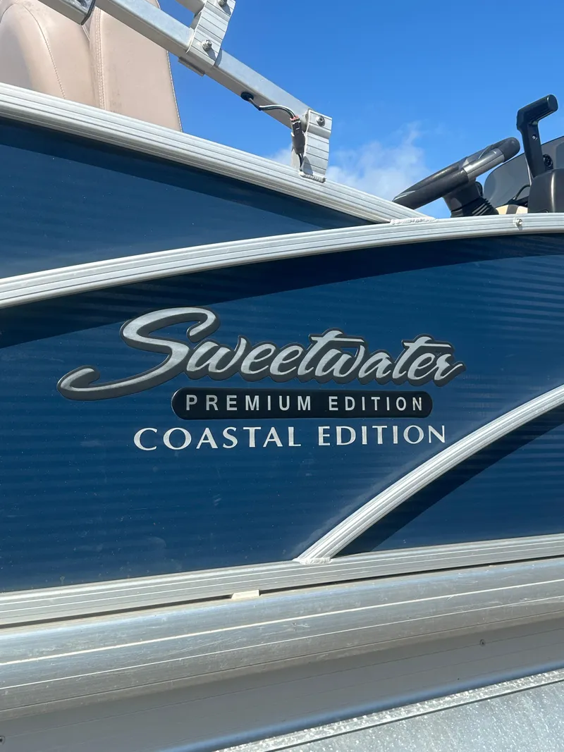 Slide: The Image of 2015 Godfrey Sweetwater 220 Premium Edition Coastal Edition boat, blue exterior with logo. - 5