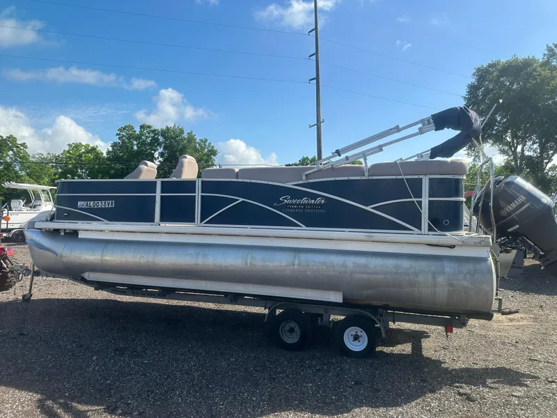 Slide: The Image of 2015 Godfrey Sweetwater 220 Premium Edition pontoon boat on trailer, under clear blue sky. - 8