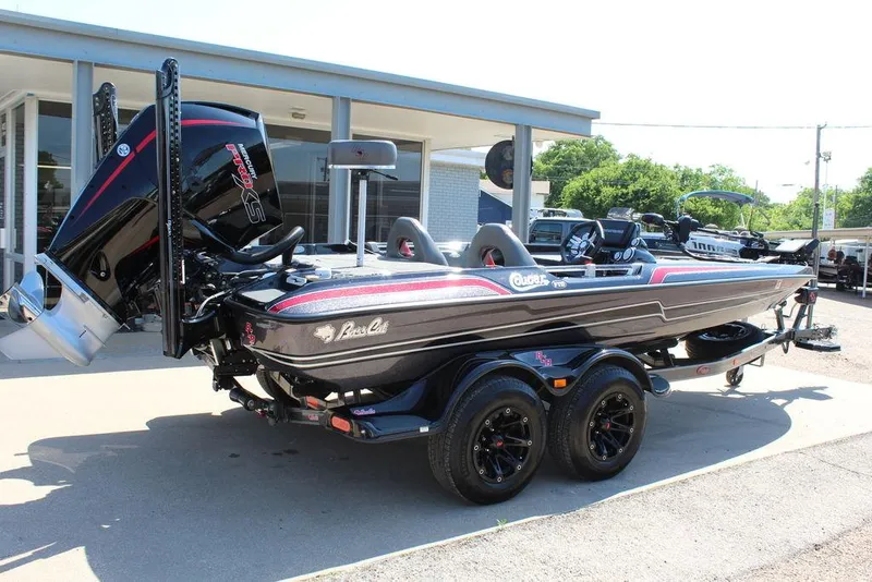 Slide: The Image of 2021 Bass Cat Cougar FTD boat on trailer, black with red accents, parked outdoors. - 3