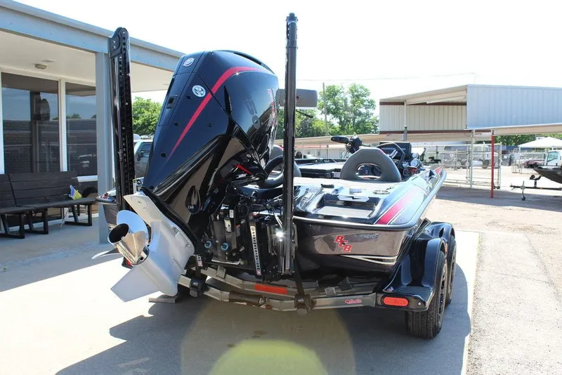 Slide: The Image of 2021 Bass Cat Cougar FTD boat, rear view, parked outdoors, showcasing powerful engine and sleek design. - 7