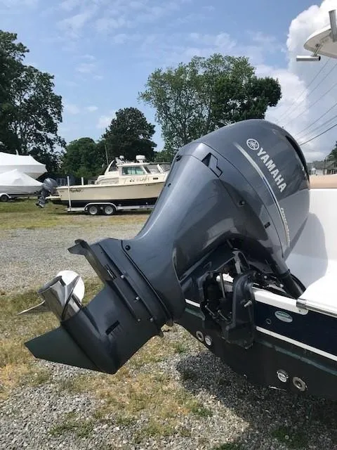 Slide: The Image of 2020 Sportsman Open 232 Center Console with Yamaha outboard motor, parked on gravel. - 18