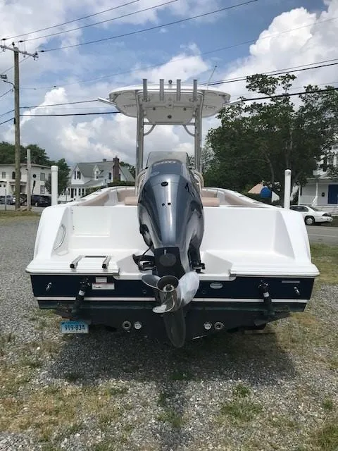 Slide: The Image of 2020 Sportsman Open 232 Center Console boat, rear view with outboard motor, parked on gravel. - 21