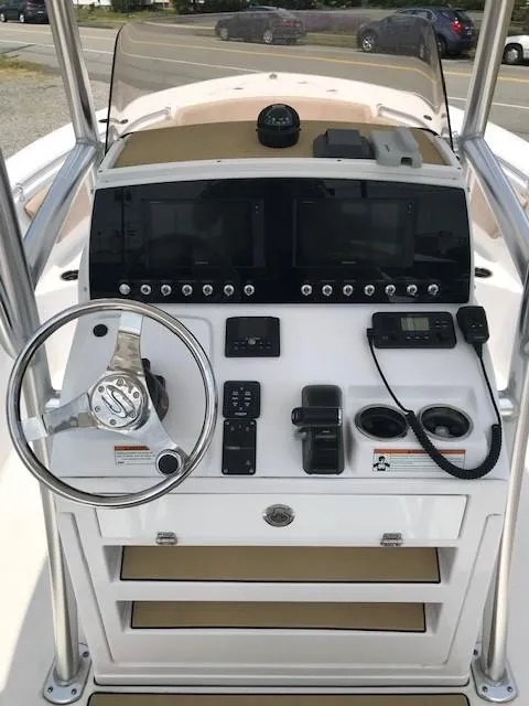 Slide: The Image of 2020 Sportsman Open 232 Center Console boat dashboard with steering wheel and navigation controls. - 6