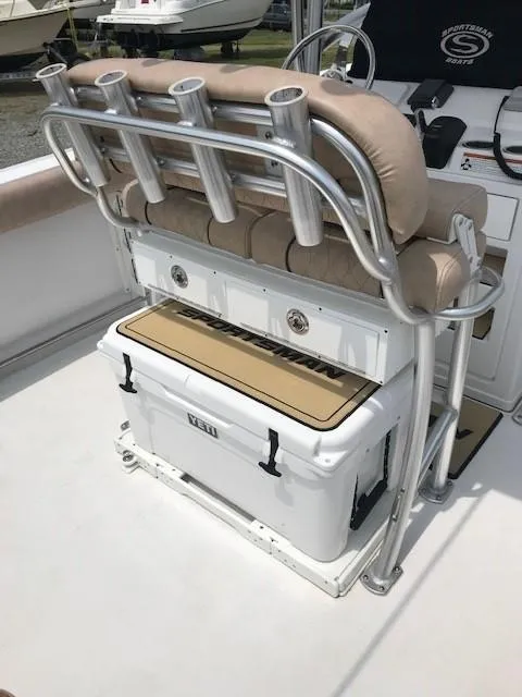 Slide: The Image of 2020 Sportsman Open 232 Center Console boat seating with rod holders and cooler. - 7