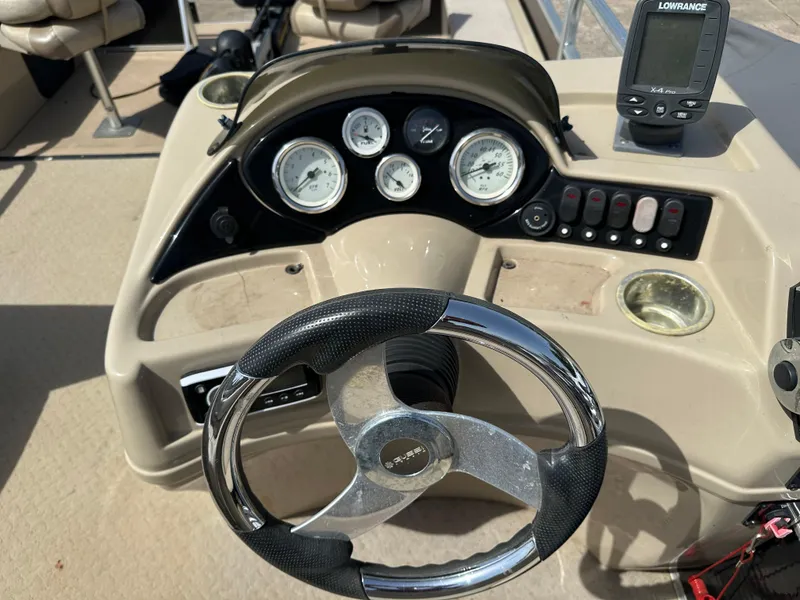 Slide: The Image of Steering console of a 2014 Lowe SF214 Sport Fish boat with gauges and navigation equipment. - 12