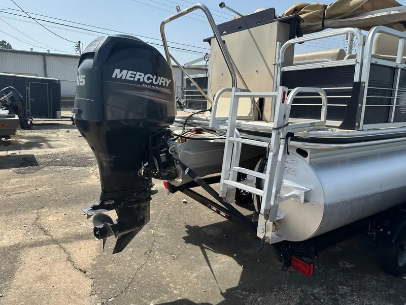 Slide: The Image of 2014 Lowe SF214 Sport Fish pontoon boat with Mercury outboard motor, parked outdoors. - 3