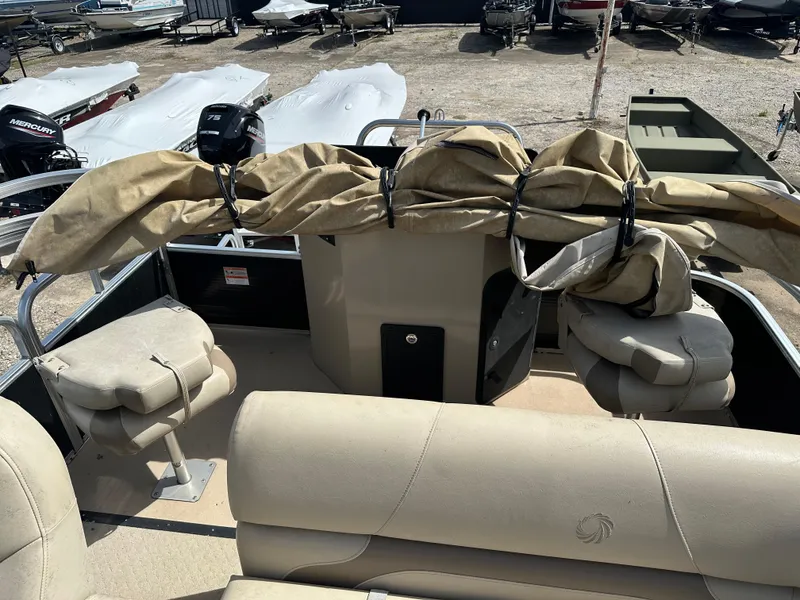 Slide: The Image of 2014 Lowe SF214 Sport Fish boat interior with beige seating and covered equipment. - 8