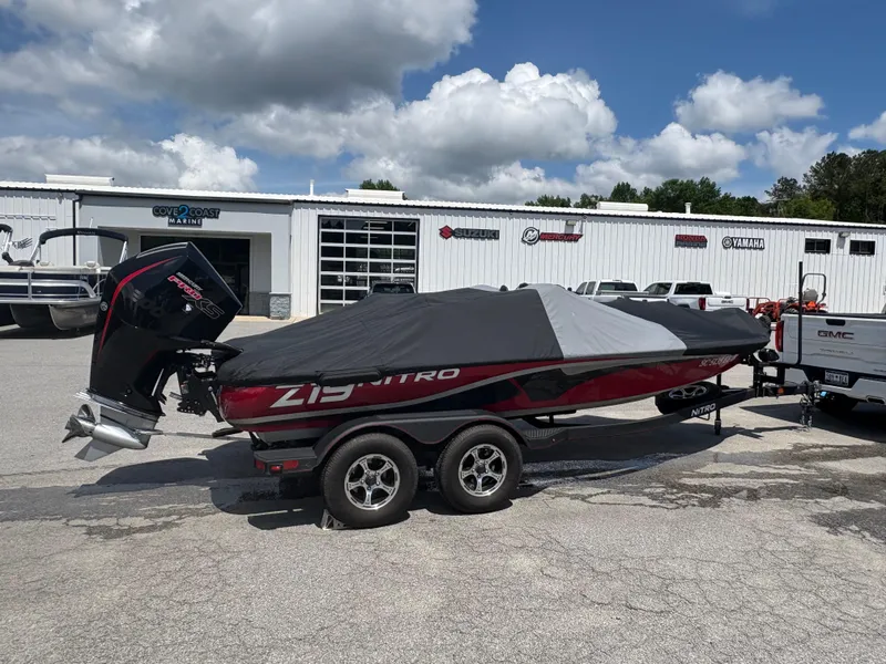 Slide: The Image of 2024 Nitro Z19 boat on trailer, covered, parked outside dealership under cloudy sky. - 3