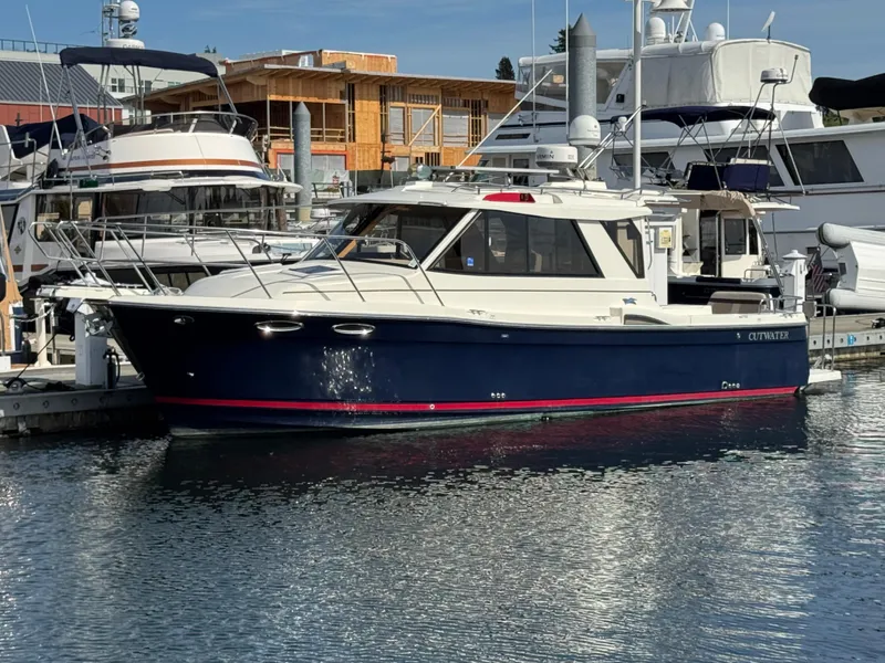 Slide: The Image of 2014 Cutwater C-28 Coupe docked at a marina, surrounded by other boats. - 1