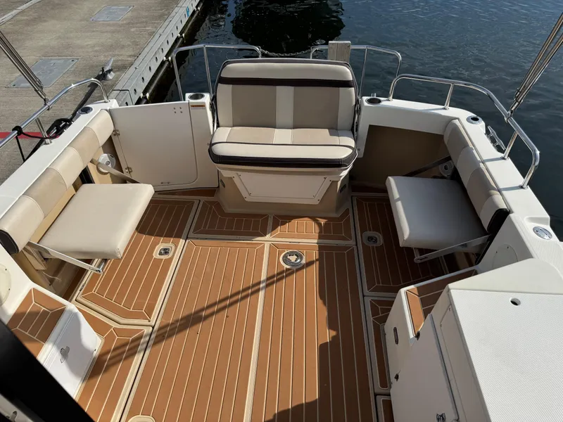 Slide: The Image of 2014 Cutwater C-28 Coupe boat interior with cushioned seating and wood-patterned flooring. - 12