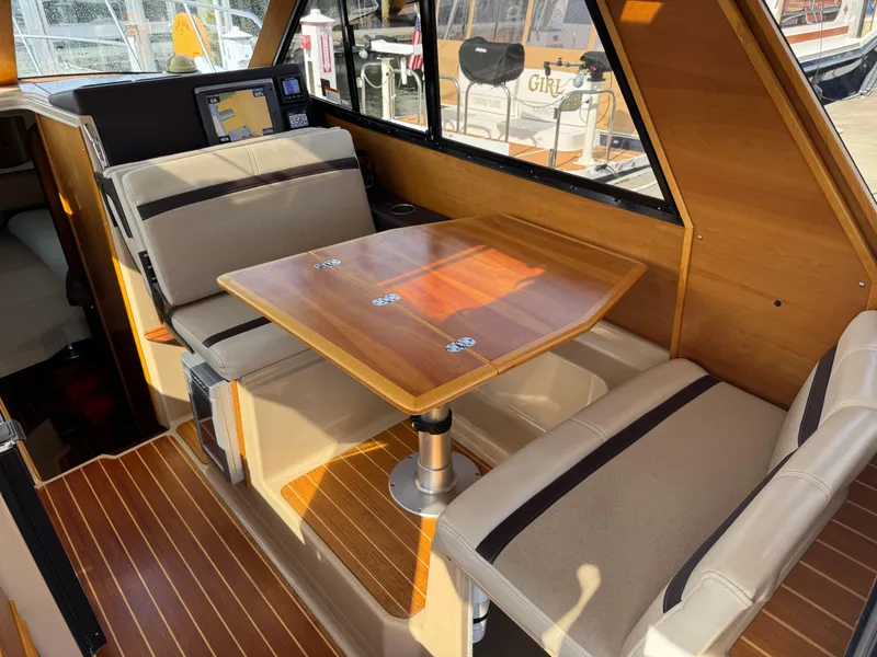 Slide: The Image of Interior of 2014 Cutwater C-28 Coupe with wooden table and cushioned seating. - 19