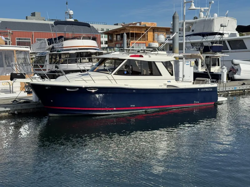 Slide: The Image of 2014 Cutwater C-28 Coupe boat docked at marina, surrounded by other vessels. - 2