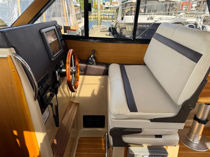 Slide: The Image of 2014 Cutwater C-28 Coupe helm with steering wheel, navigation controls, and cushioned seating. - 21