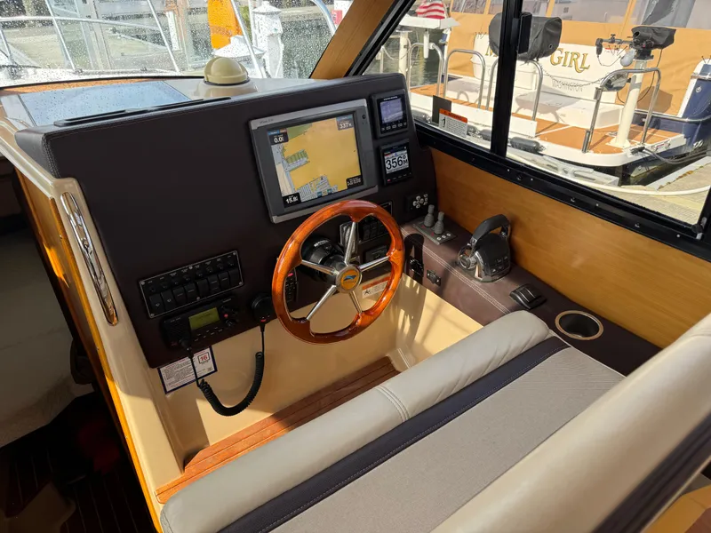 Slide: The Image of 2014 Cutwater C-28 Coupe helm with GPS, wooden steering wheel, and control panel. - 22