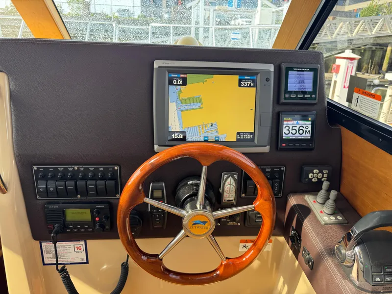 Slide: The Image of 2014 Cutwater C-28 Coupe helm with navigation screens and wooden steering wheel. - 23