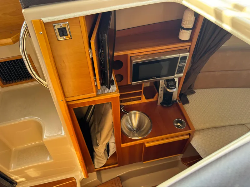 Slide: The Image of 2014 Cutwater C-28 Coupe interior with kitchenette, microwave, and sink. - 28