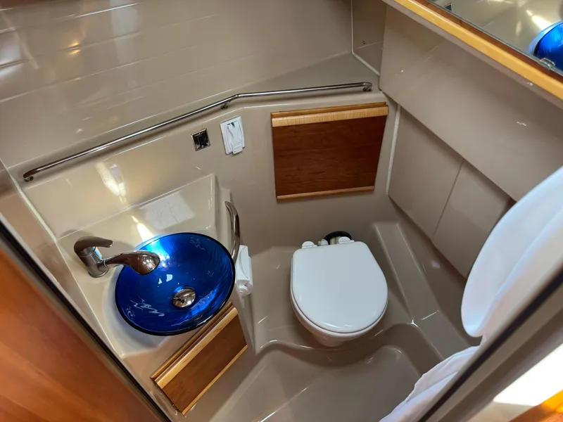 Slide: The Image of 2014 Cutwater C-28 Coupe bathroom with blue glass sink and modern fixtures. - 30