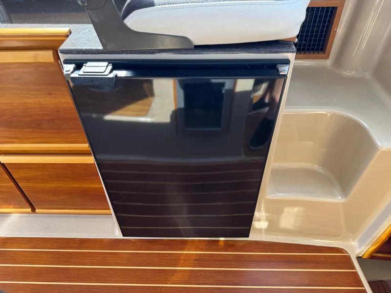 Slide: The Image of 2014 Cutwater C-28 Coupe interior with sleek black fridge and wooden cabinetry. - 39