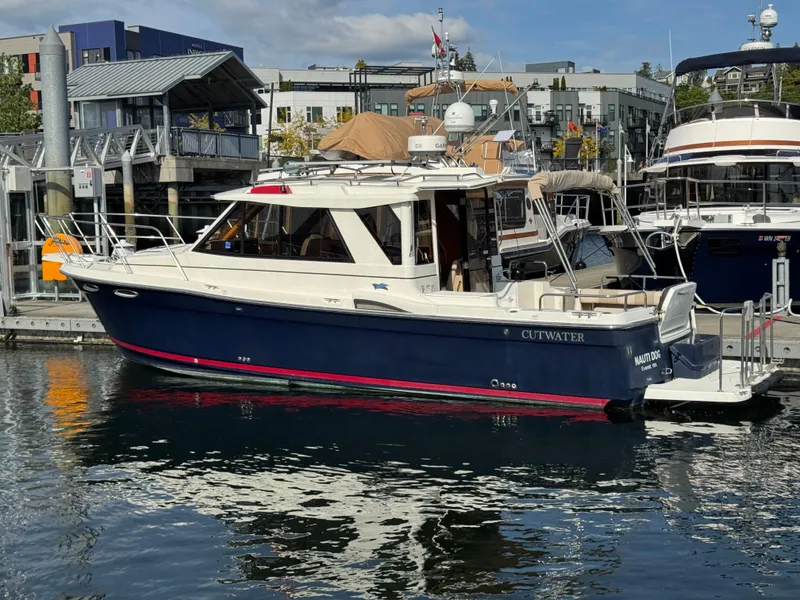 Slide: The Image of 2014 Cutwater C-28 Coupe boat docked at a marina, featuring a sleek design. - 4