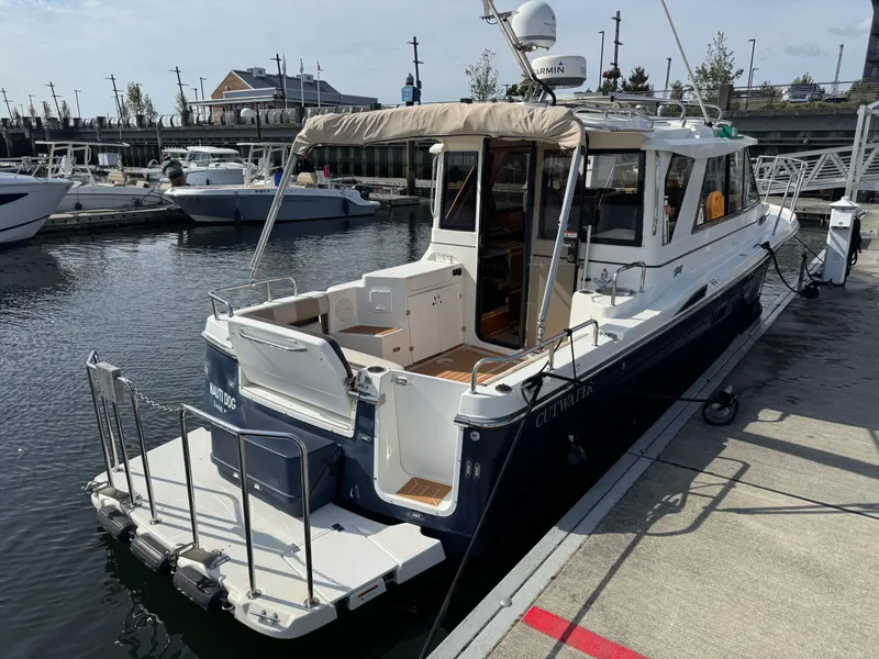 Slide: The Image of 2014 Cutwater C-28 Coupe docked at a marina, showcasing its sleek design and spacious deck. - 7