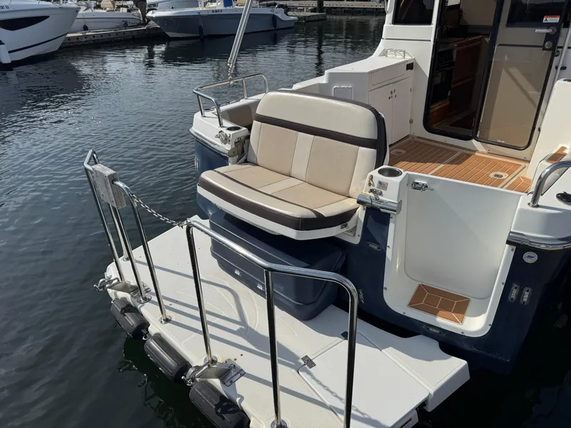 Slide: The Image of 2014 Cutwater C-28 Coupe boat with rear seating and swim platform on calm water. - 9