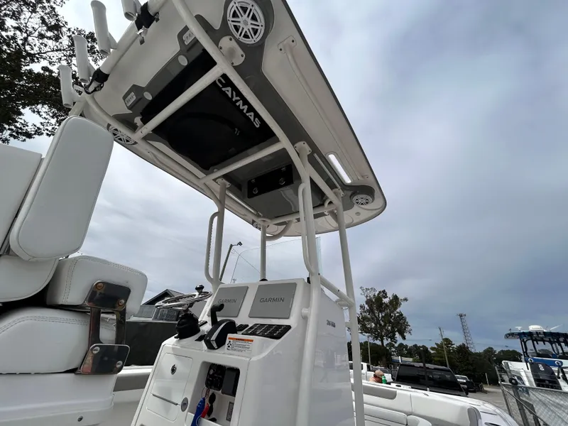 Slide: The Image of 2024 Caymas 26 HB boat console with T-top and electronics, under a cloudy sky. - 5