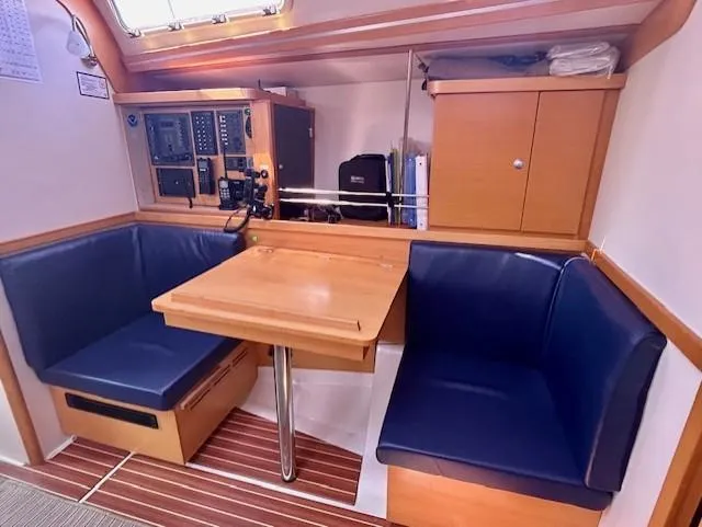 Slide: The Image of Interior of 2007 Hanse 400 yacht with blue seating and wooden table. - 23