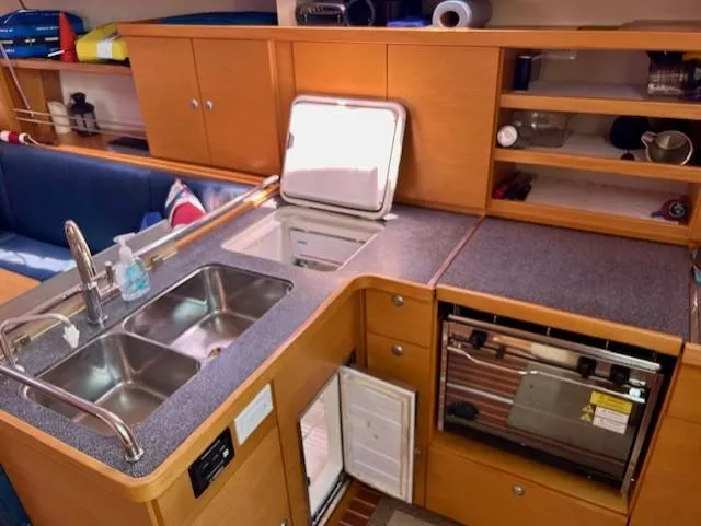 Slide: The Image of 2007 Hanse 400 yacht kitchen with double sink, stove, and storage cabinets. - 25