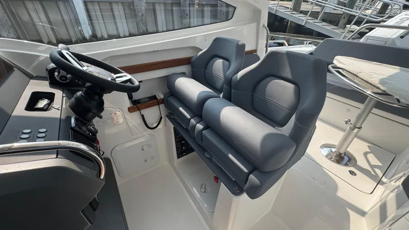 Slide: The Image of 2024 Nimbus W9 boat interior with dual seats and steering console. - 12