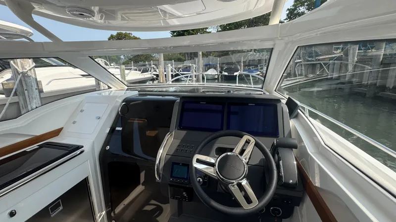 Slide: The Image of 2024 Nimbus W9 boat cockpit with modern steering and navigation displays. - 13