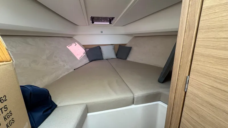 Slide: The Image of 2024 Nimbus W9 cabin interior with beige cushions and pillows. - 15