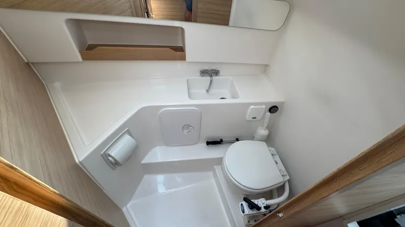 Slide: The Image of 2024 Nimbus W9 boat bathroom with compact sink, toilet, and storage shelf. - 16