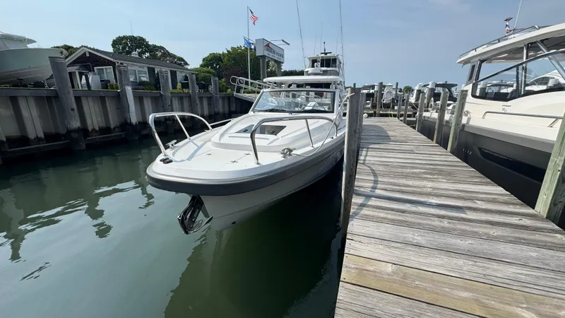 Slide: The Image of 2024 Nimbus W9 boat docked at a marina, calm water, clear sky. - 2