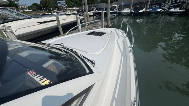 Slide: The Image of 2024 Nimbus W9 boat docked in a marina, surrounded by other vessels. - 20