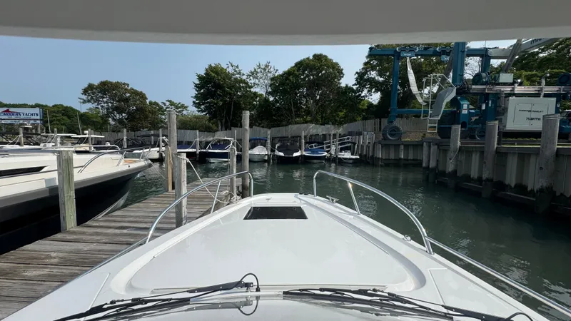 Slide: The Image of 2024 Nimbus W9 boat docked at a marina, surrounded by other boats and trees. - 22