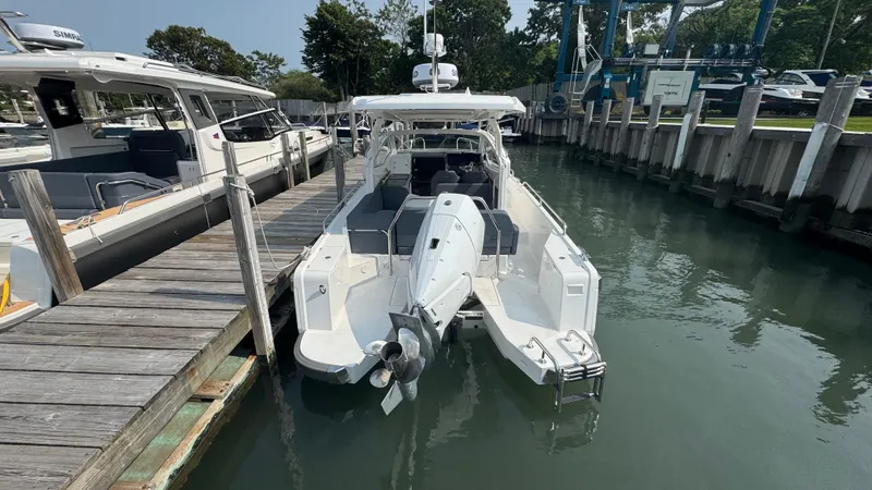 Slide: The Image of 2024 Nimbus W9 boat docked at marina, rear view showing outboard motor. - 3