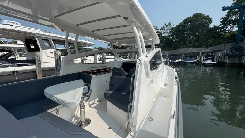 Slide: The Image of 2024 Nimbus W9 boat with sleek design, spacious seating, docked in a marina. - 7